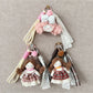 Front view of Keypus double ponytail fabric doll keychain with smiling face
