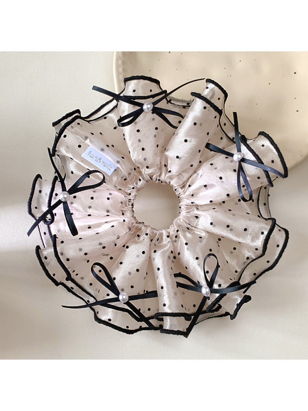 Gifty satin polka dot bow scrunchie styled in a ponytail on a model