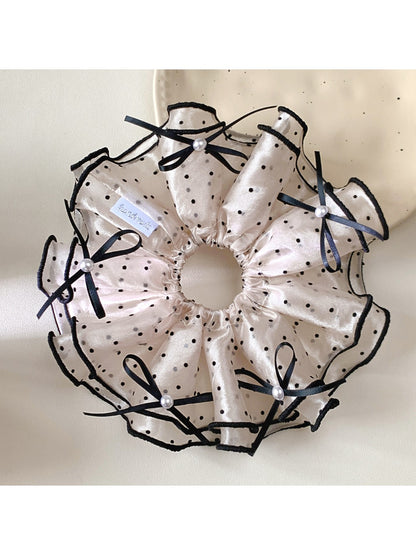 Gifty satin polka dot bow scrunchie styled in a ponytail on a model