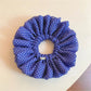 Chic blue scrunchie with white polka dots on a white background