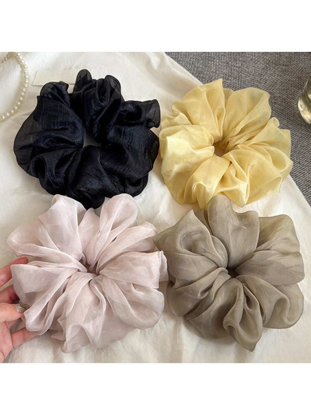 Solid color ruched scrunchie stretched slightly to show elasticity