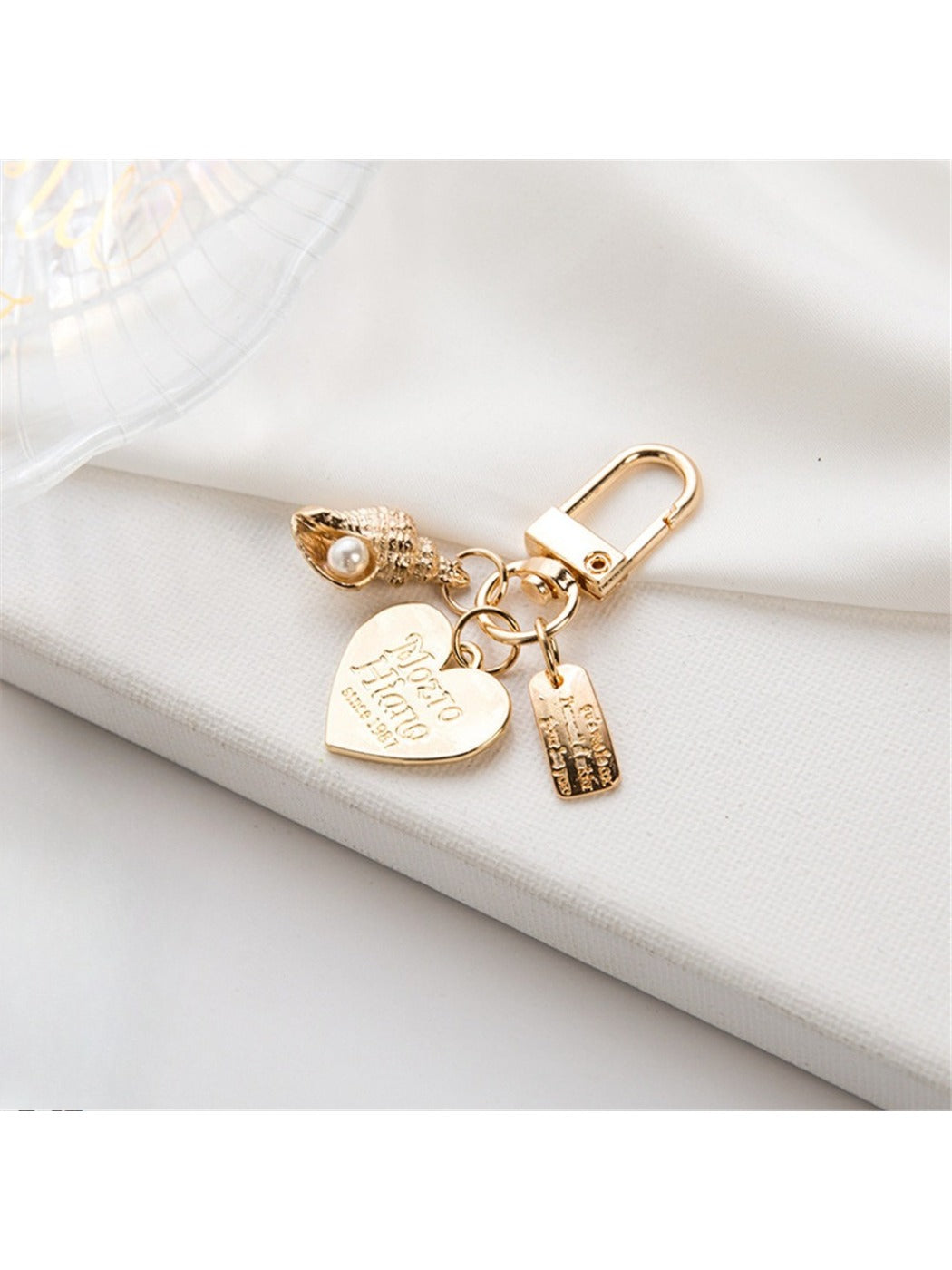Alloy heart keychain hanging from a bag zipper pull