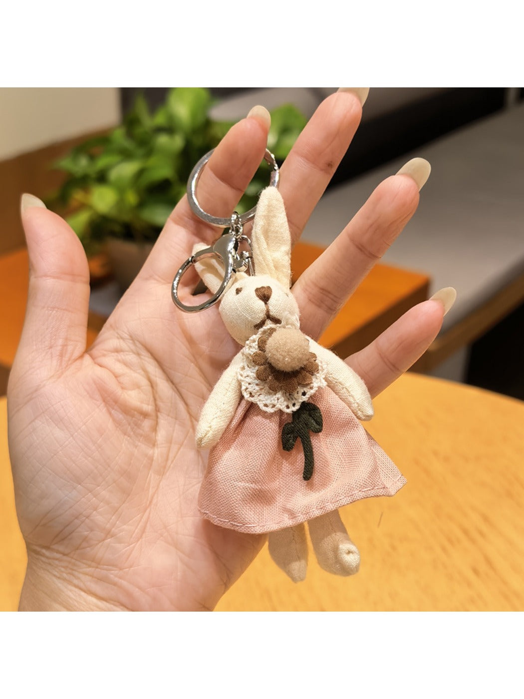 Rabbit charm keychain on a wooden table with natural light