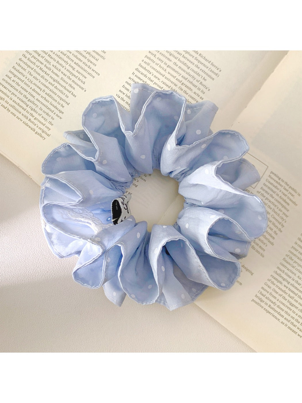 Blue double layer scrunchie held in hand showing texture