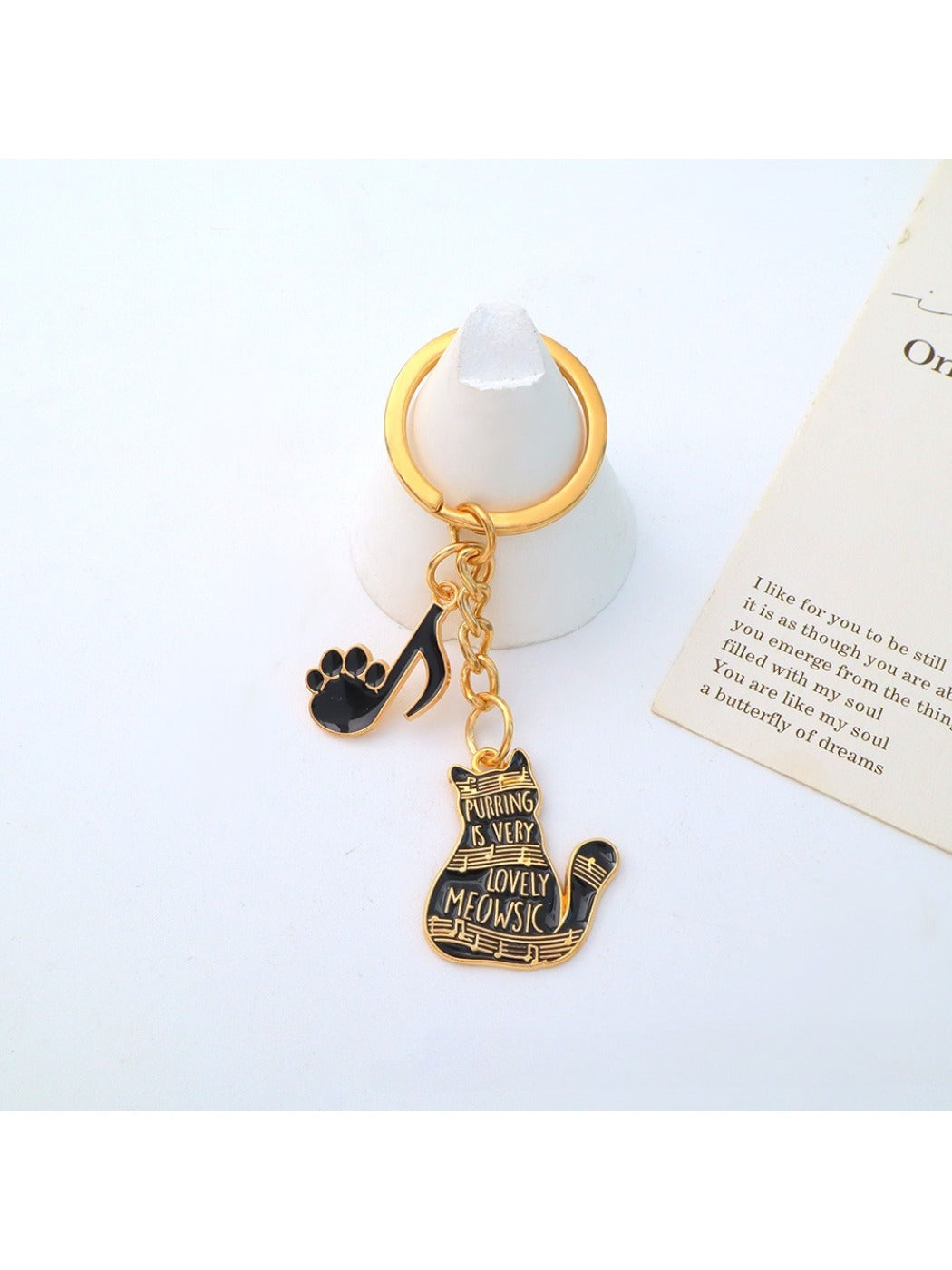 Cartoon cat piano keychain shown next to a smartphone for size comparison