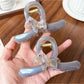 Close-up of Beau purple pony print claw clip showing curved teeth