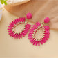 Top view of raffia teardrop hollow earrings highlighting natural fibers