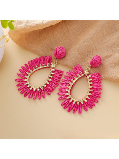 Top view of raffia teardrop hollow earrings highlighting natural fibers