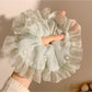 Close-up of mint green mesh fabric with white polka dots on scrunchie