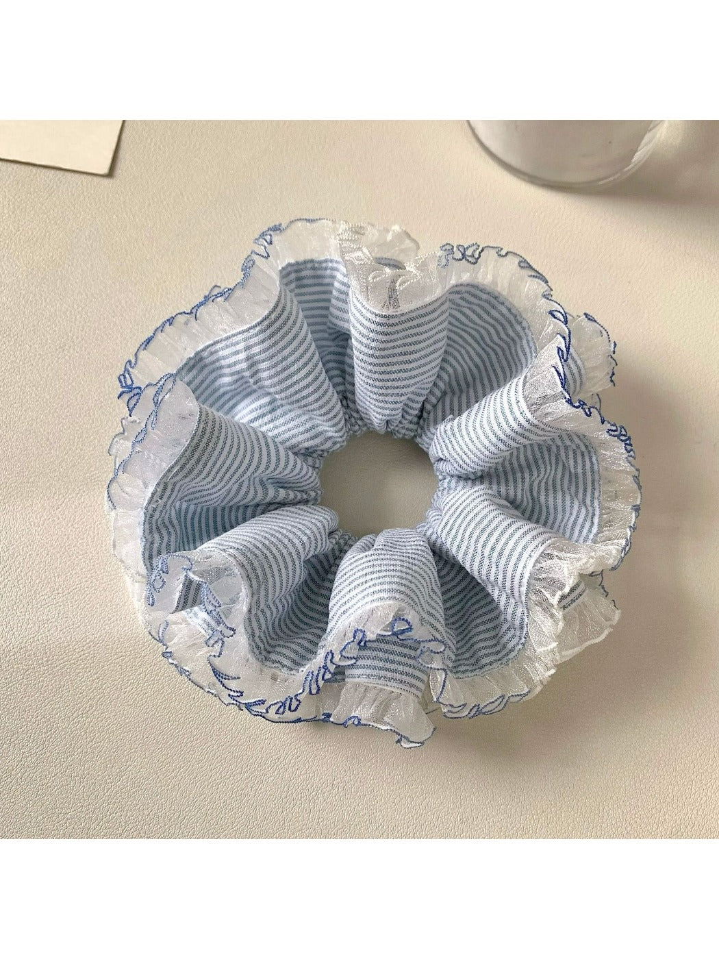 Close-up of navy blue striped scrunchie showing fabric texture and elastic band