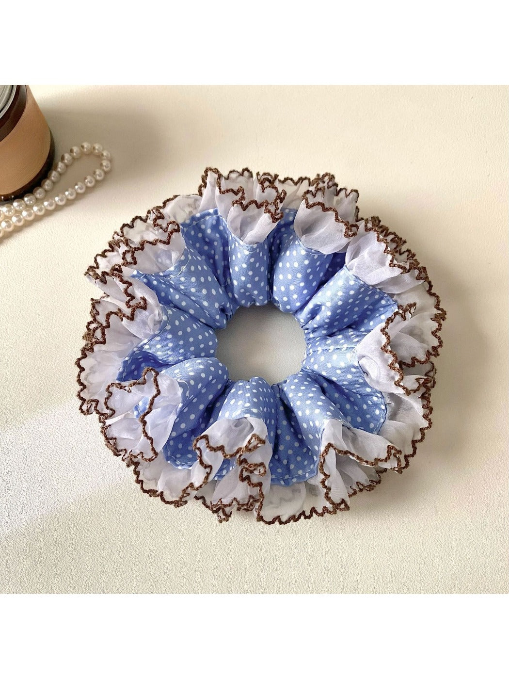 Gifty scrunchie styled on a wrist with black and white polka dots