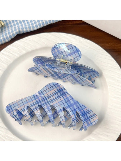 Blue plaid shark hair claw clip held in hand showing size and texture