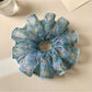 Gifty scrunchie worn on a model's wrist showcasing vintage floral print