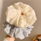 Gifty ruched scrunchie wrapped around a ponytail on a model