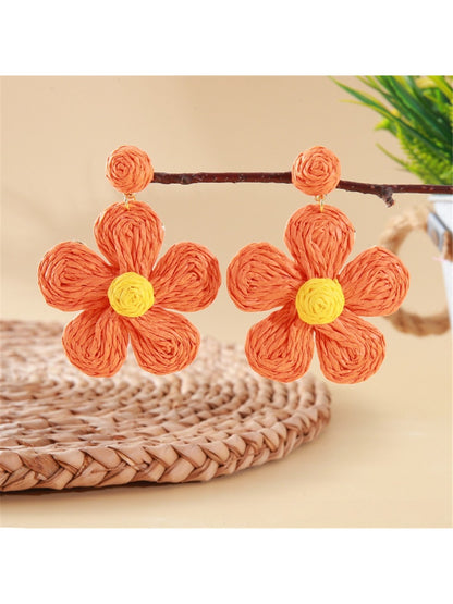 Earedge flower shaped knitted earrings hanging from a jewelry stand