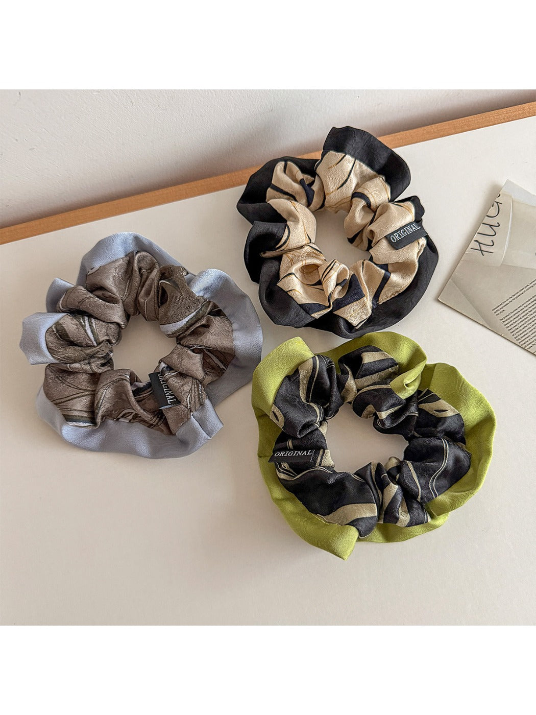 Close-up of Gifty color block print scrunchie with pink, orange, and white sections