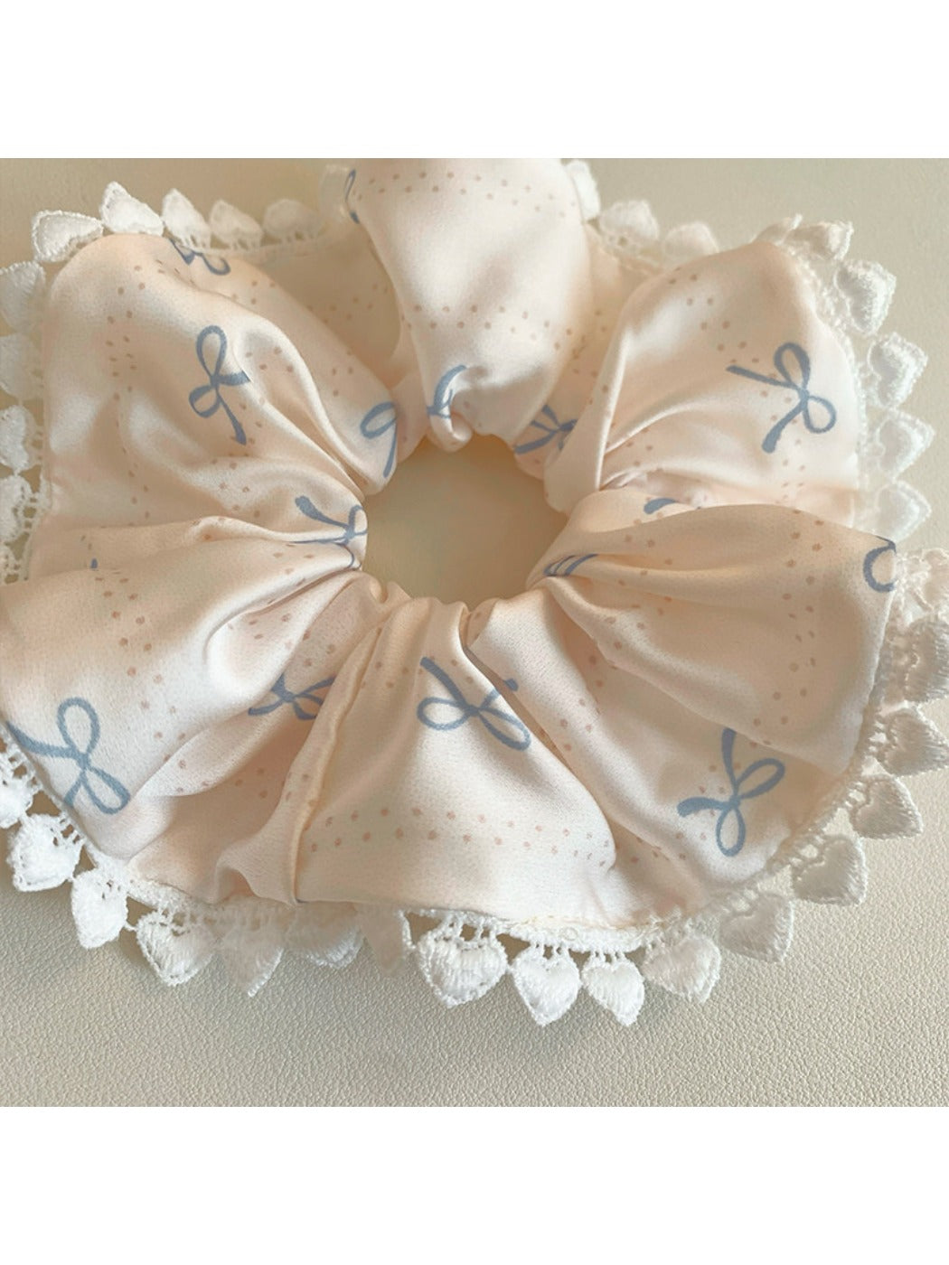 Gifty satin bow print scrunchie displayed on a white surface