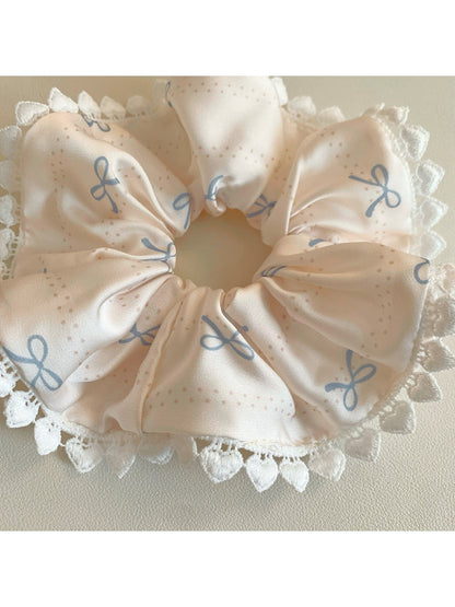 Gifty satin bow print scrunchie displayed on a white surface