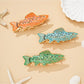 Beau personalized fish shaped hair clip with engraved name on light wood