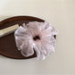 Gifty solid color scrunchie placed on a white surface with soft lighting