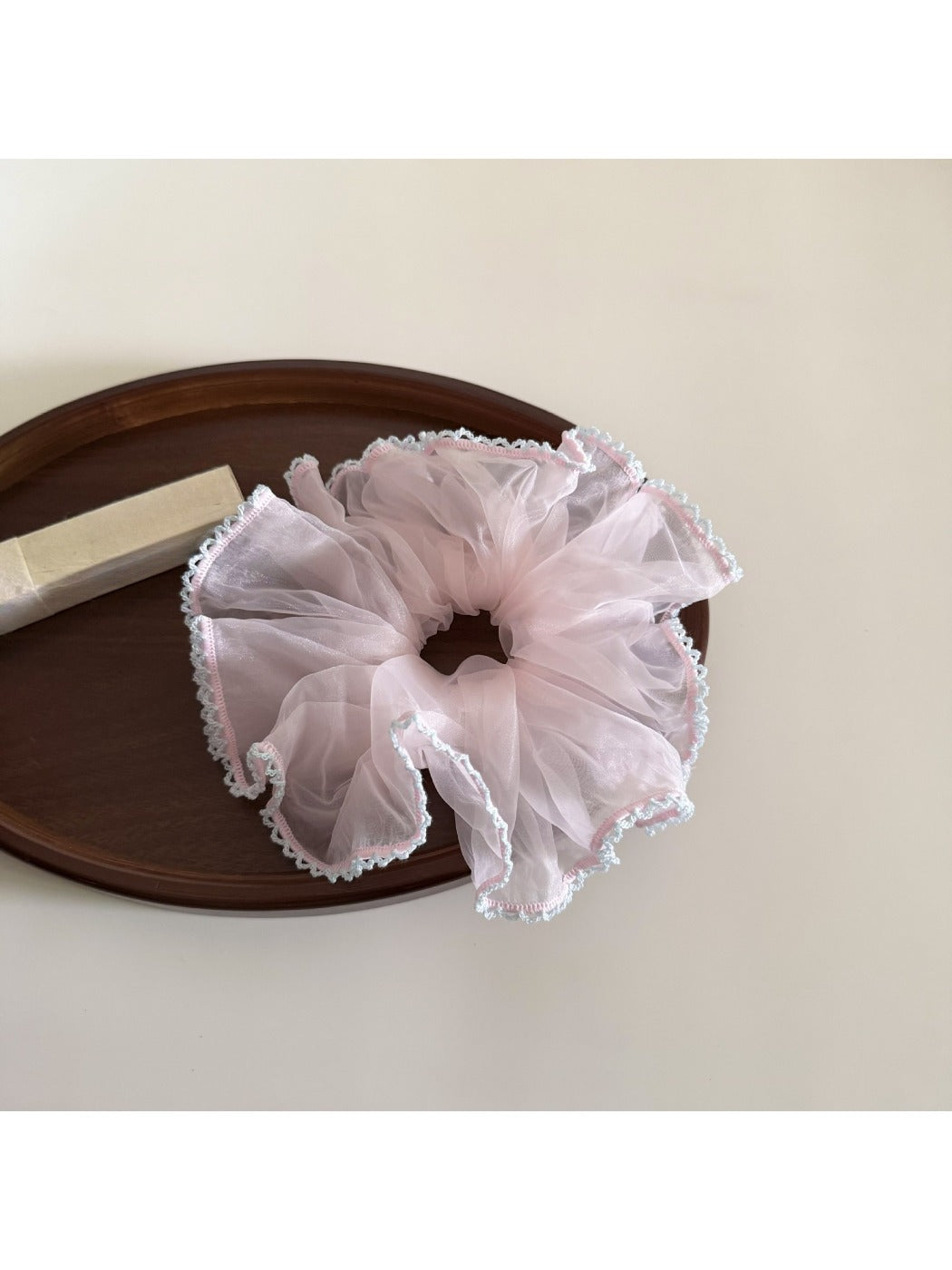 Gifty solid color scrunchie placed on a white surface with soft lighting