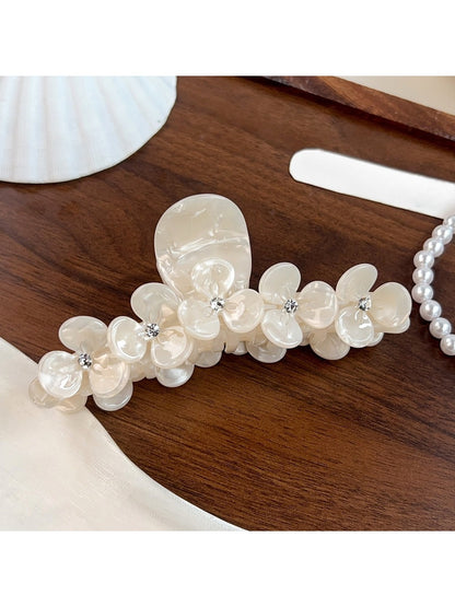Beau floral half round claw clip displayed on a wooden surface