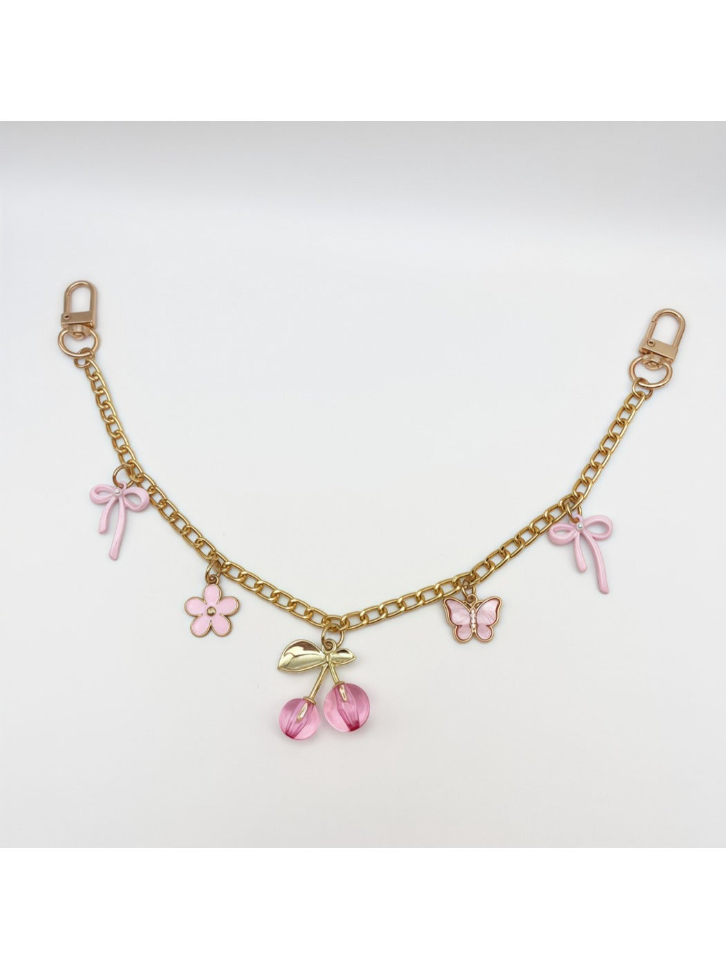 Cherry bag charm displayed on a wooden surface with soft lighting
