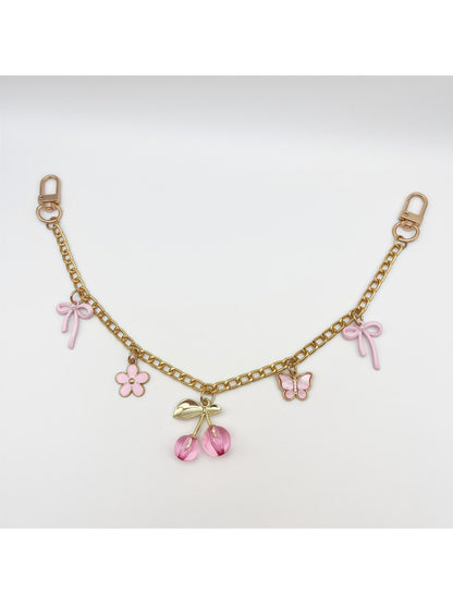 Cherry bag charm displayed on a wooden surface with soft lighting