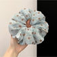 Polka dot ruched scrunchie displayed on a white background