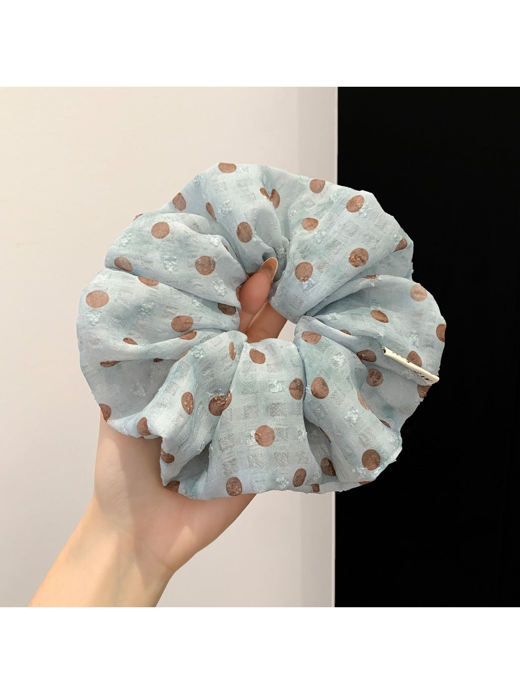 Polka dot ruched scrunchie displayed on a white background