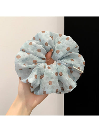 Polka dot ruched scrunchie displayed on a white background