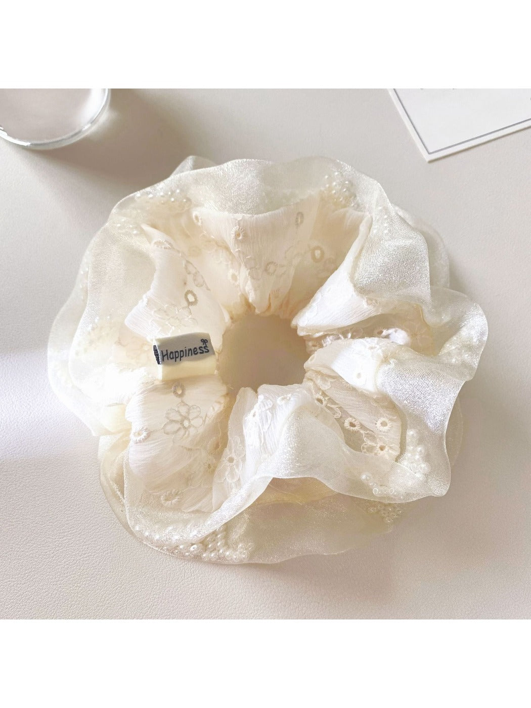 White tulle scrunchie stretched slightly to show elasticity