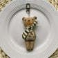 Fabric bear cub bag charm keychain displayed with a set of keys