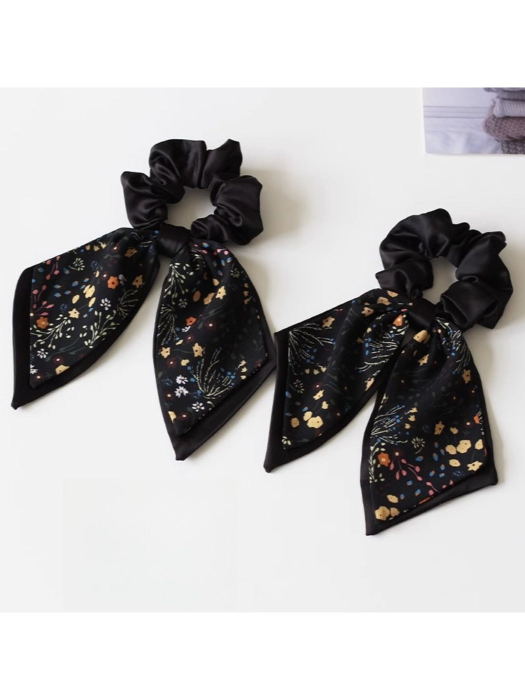Gifty printed bow hair tie displayed on a wooden surface showing fabric texture