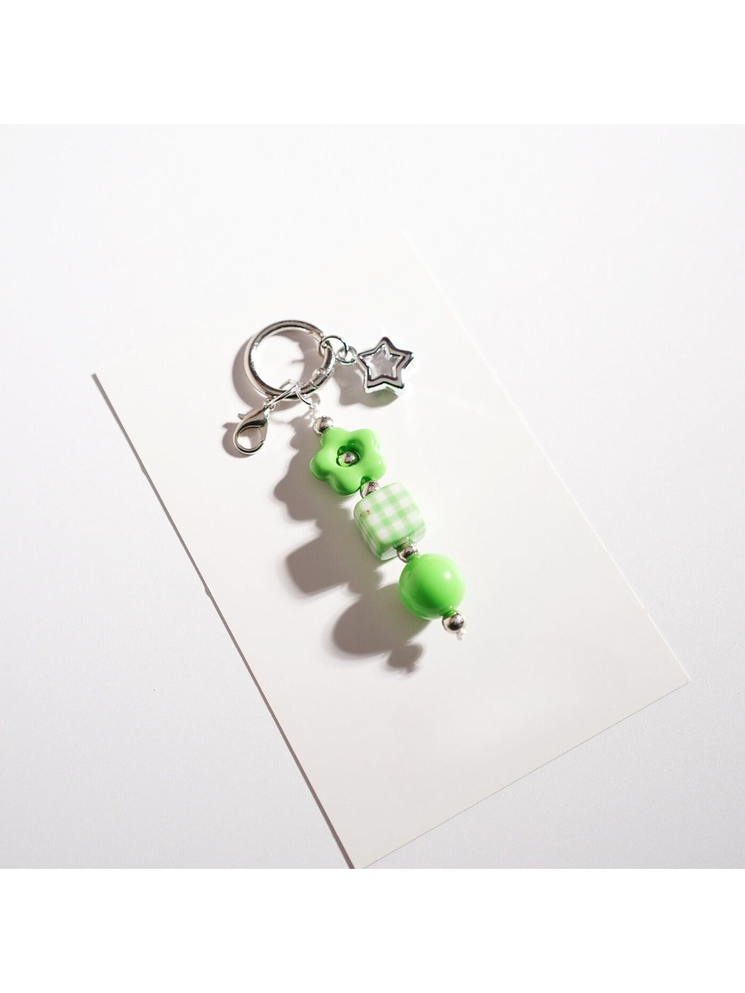 Hand holding the Keypus beaded star-shaped keychain against a blurred background