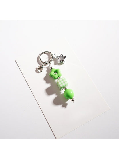Hand holding the Keypus beaded star-shaped keychain against a blurred background