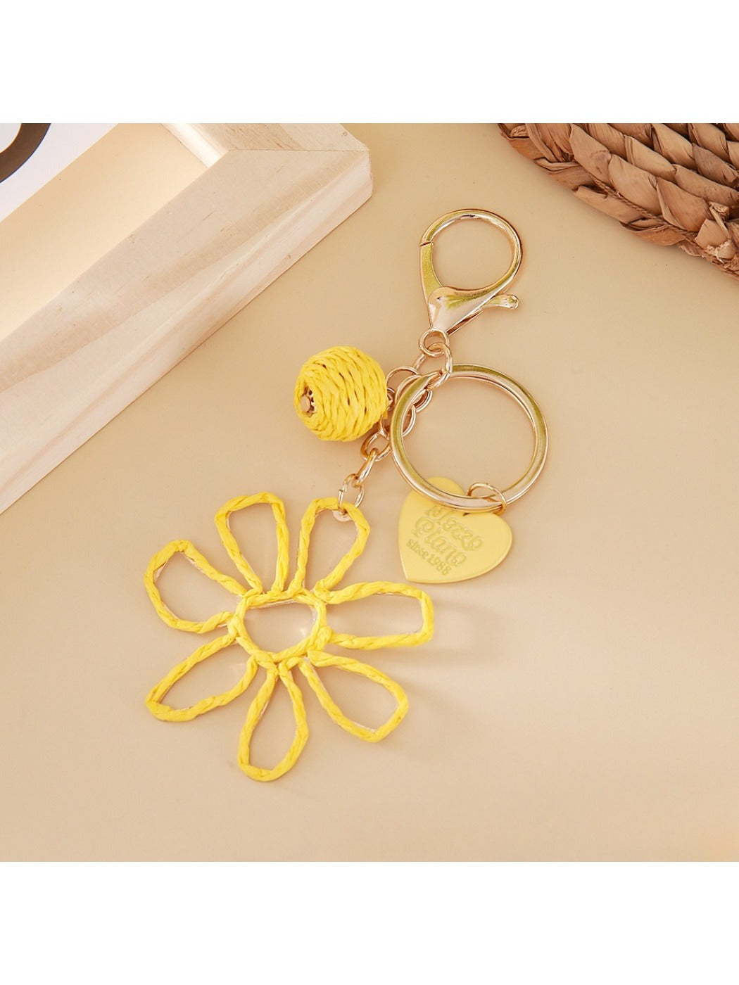Raffia flower keychain attached to a set of keys on a wooden surface