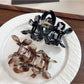 Beau floral hair claw clip displayed on a wooden surface with soft lighting