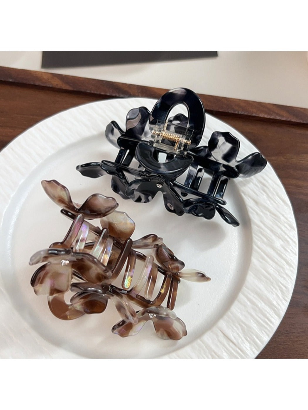 Beau floral hair claw clip displayed on a wooden surface with soft lighting