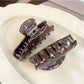 Beau claw clip open, displaying inner teeth and butterfly print