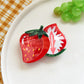 Multiple Beau fruit shaped hair clips arranged in a row showing variety