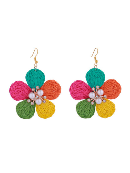 Side view of raffia flower earrings highlighting the layered petal design and lightweight construction