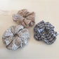 Gifty minimalist plaid scrunchie displayed on a wooden surface with soft lighting