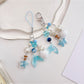 Keychain attached to a set of keys featuring the blue drift bottle charm