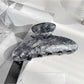 Beau claw clip resting on fabric surface highlighting smooth finish