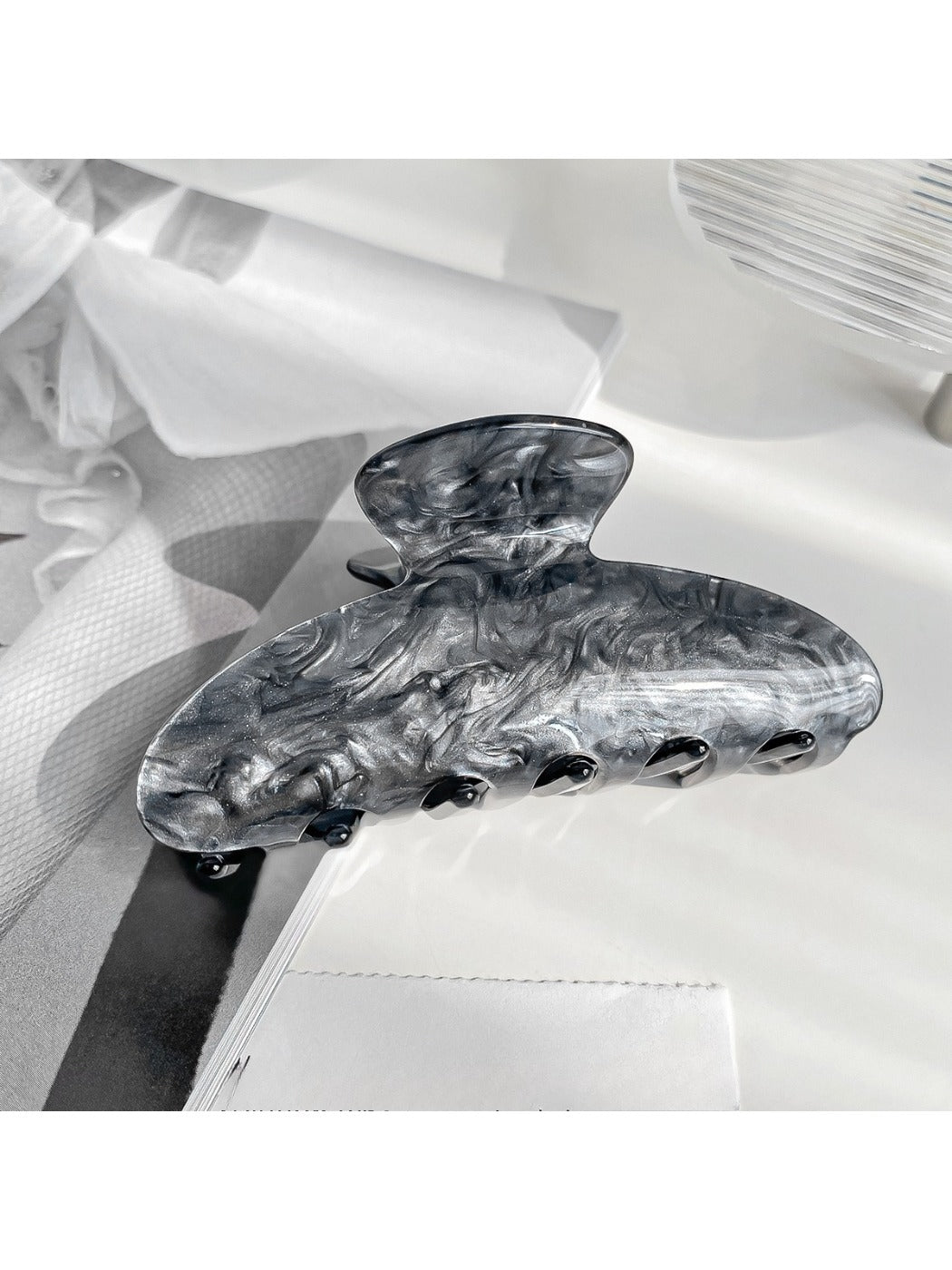 Beau claw clip resting on fabric surface highlighting smooth finish