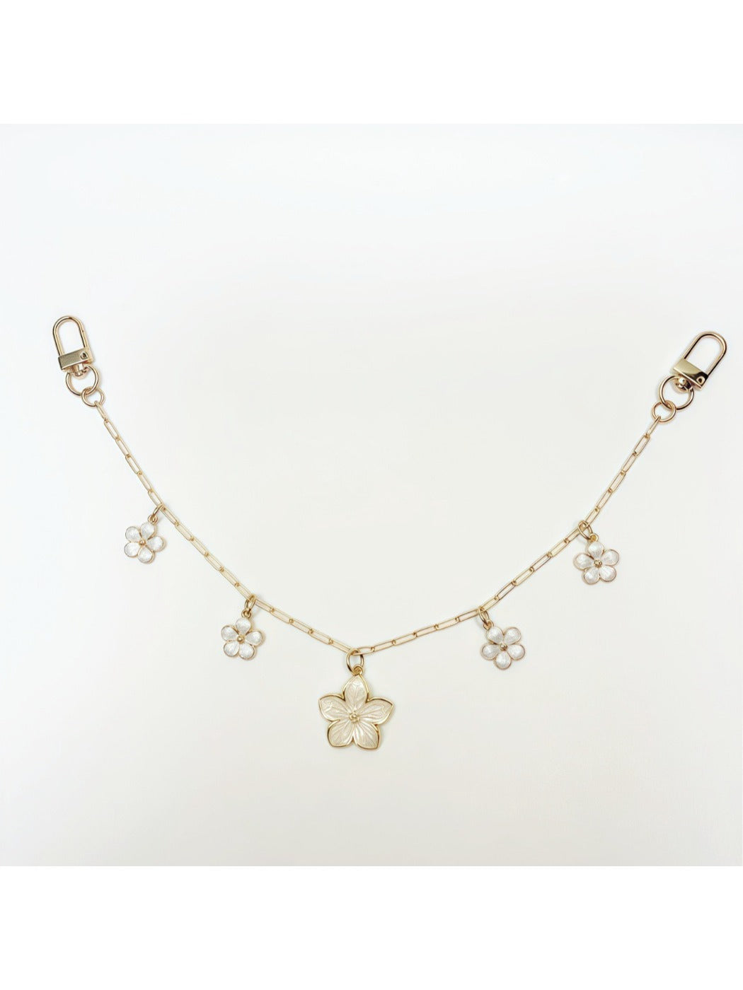 Hand holding the cherry blossom pendant charm showing its size relative to fingers