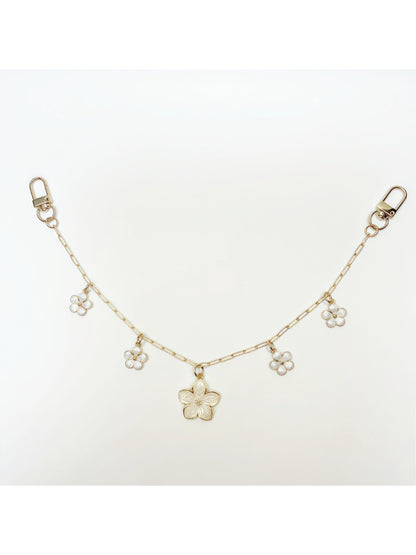 Hand holding the cherry blossom pendant charm showing its size relative to fingers
