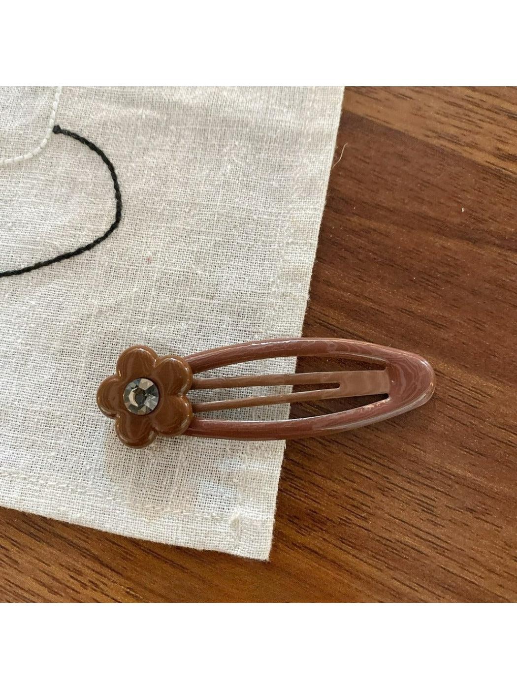 Beau flower pattern hair clip angled to show thickness and clasp mechanism