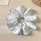 Close-up of Gifty solid color polka dot scrunchie on white background